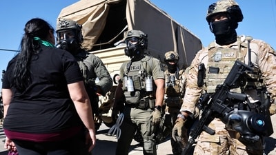 Federal agents block people protesting an ICE immigration raid at a nearby licensed cannabis farm near Camarillo (Getty Images via AFP) Federal agents block people protesting an ICE immigration raid at a nearby licensed cannabis farm near Camarillo (Getty Images via AFP)
