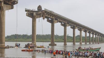 Rescuers and residents look for survivors after several vehicles fell into a river following the collapse of a portion of a bridge near Vadodara in Gujarat on July 9. (AP)