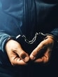 Arrested computer hacker and cyber criminal with handcuffs, close up of hands (Getty Images/iStockphoto)