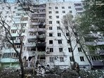 Firefighters and a police officer work at the site of an apartment building damaged during Russian drone and missile strikes