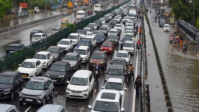 Traffic congestion on National Highway-48 due to waterlogging on the service road after heavy rain near the foot overbridge in Narsinghpur village, in Gurugram. (Parveen Kumar/Hindustan Times)