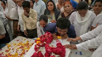 Relatives mourning by the coffins of victims, who were killed in the Air India flight AI171 crash. (Dibyangshu Sarkar/AFP File)