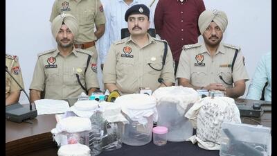 Police officials showing the seized firearms and other material in Sangrur on Saturday. (HT)