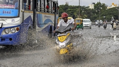 A biker rides through a waterlogged road after rainfall, in Bengaluru, on Friday. (PTI) A biker rides through a waterlogged road after rainfall, in Bengaluru, on Friday. (PTI)