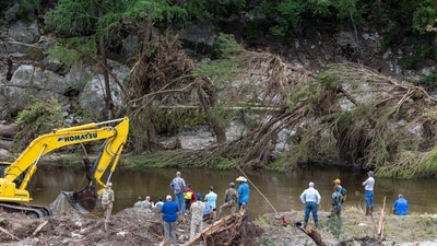 Members of a search and rescue team search for missing people amid debris in the waters of the Guadalupe River, near Camp Mystic. (REUTERS)