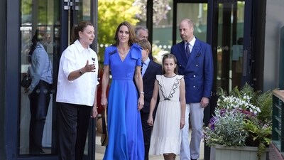 Britain's Prince William, Kate, Princess of Wales, center left, Prince George, center, and Princess Charlotte, center right, are greeted by Sally Ambrose, left, a member of the Committee of Management of The Championships. (Andrew Matthews/Pool via AP) (AP)