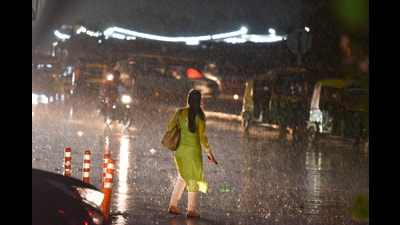 Commuters caught in the rain on National Highway-48 near Rajiv Chowk in Gurugram on Sunday. (Parveen Kumar/HT Photo)