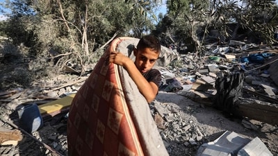 A Palestinian boy salvages a mattress from the rubble of a house in the aftermath of an overnight Israeli strike that hit Nuseirat (AFP) A Palestinian boy salvages a mattress from the rubble of a house in the aftermath of an overnight Israeli strike that hit Nuseirat (AFP)