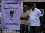 People stand next to a condolence banner as they wait for the body of Sumeet Sabharwal, a pilot who died when an Air India Boeing 787-8 Dreamliner crashed during take-off in Ahmedabad on June 12. 