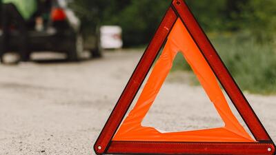 Driver putting warning triangle on asphalt road. Emergency stop concept. Driver putting warning triangle on asphalt road. Emergency stop concept.