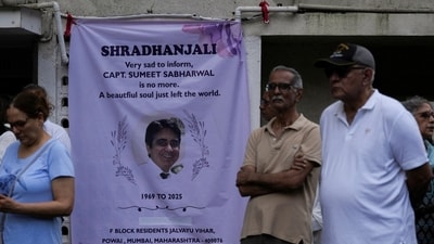 People stand next to a condolence banner as they wait for the body of Sumeet Sabharwal, a pilot who died when an Air India Boeing 787-8 Dreamliner crashed during take-off in Ahmedabad on June 12. (Reuters file)