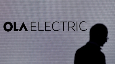 A man walks past the logo of Ola Electric during a press conference ahead of it's IPO launch in Mumbai, India, July 29, 2024. (Reuters)