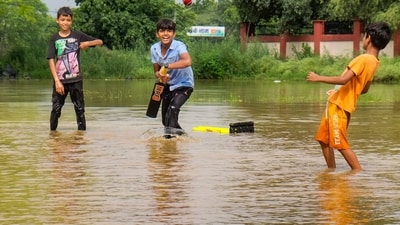 Children play cricket at a waterlogged ground after heavy rains, in Gurugram. (PTI)