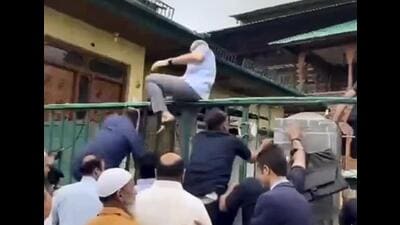 This screengrab shows Jammu and Kashmir chief minister Omar Abdullah climbing a fence to pay tributes to July 13 martyrs at Naqshband Sahib graveyard in the Old City of Srinagar on Monday. (PTI Photo) This screengrab shows Jammu and Kashmir chief minister Omar Abdullah climbing a fence to pay tributes to July 13 martyrs at Naqshband Sahib graveyard in the Old City of Srinagar on Monday. (PTI Photo)