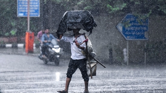 Delhi rain LIVE updates: A man crosses road amid heavy rainfall, in New Delhi. Delhi rain LIVE updates: A man crosses road amid heavy rainfall, in New Delhi.