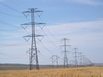 (FILES) Large electrical transmission lines run through grass lands to power the newly completed Meta�s Facebook data center in Eagle Mountain, Utah on July 18, 2024. In a scramble to quickly bring more data centers online, US cloud computing giants are now getting directly involved in energy production. And while they are using some renewable energy options and trying to revive nuclear power, they are also turning to fossil fuels like gas, which in the United States is relatively cheap. A fight in Davis, in the woods of rural West Virginia, is the latest example of the war between the US tech sector -- and its rapidly rising need for energy to power the AI boom -- and the communities it affects. (Photo by GEORGE FREY / AFP)