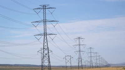 (FILES) Large electrical transmission lines run through grass lands to power the newly completed Meta�s Facebook data center in Eagle Mountain, Utah on July 18, 2024. In a scramble to quickly bring more data centers online, US cloud computing giants are now getting directly involved in energy production. And while they are using some renewable energy options and trying to revive nuclear power, they are also turning to fossil fuels like gas, which in the United States is relatively cheap. A fight in Davis, in the woods of rural West Virginia, is the latest example of the war between the US tech sector -- and its rapidly rising need for energy to power the AI boom -- and the communities it affects. (Photo by GEORGE FREY / AFP) (AFP)