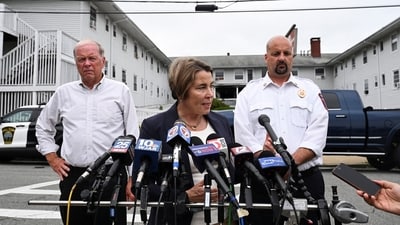 Masschusetts Governor Maura Healey speaks, as Fall River Fire Chief Jeffrey Bacon and Mayor Paul Coogan look on at Gabriel House Assisted Living Facility. (Reuters)