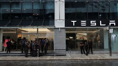 People are seen outside the Tesla showroom ahead of its opening in Mumbai. (Reuters)