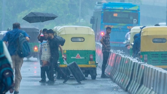 Commuters are seen during a Evening rain at ISBT Kashmere Gate Road in New Delhi, India, (RAJ K RAJ /HT PHOTO)