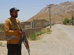 A security personnel stands guard along a street near the site of a school bus bombing in the Khuzdar district of Balochistan province.
