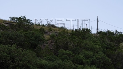 The "Mystic" sign on a hill outside Camp Mystic in Texas's Kerr County, the region which is still haunted by the deadly floods that swept the area, about two weeks ago. (Eli Hartman/Bloomberg) The "Mystic" sign on a hill outside Camp Mystic in Texas's Kerr County, the region which is still haunted by the deadly floods that swept the area, about two weeks ago. (Eli Hartman/Bloomberg)