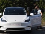 A blogger films a "Tesla Model Y" car, an all-electric compact SUV by US electric car giant Tesla, on September 5, 2020, during its presentation at the Automobile Club in Budapest.