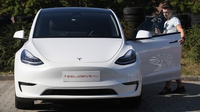 A blogger films a "Tesla Model Y" car, an all-electric compact SUV by US electric car giant Tesla, on September 5, 2020, during its presentation at the Automobile Club in Budapest. (AFP)