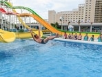 Domestic tourists watch as a man uses a slide into a swimming pool at the Myongsasimni Water Park in the Wonsan Kalma Coastal Tourist Area in Wonsan, North Korea's Kangwon Province
