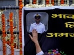 A woman touches a banner with a photo of Vinay Narwal, a Navy officer, who was killed in a terrorist attack in Pahalgam.