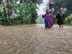 A man along with children walks through a waterlogged street during rains, in Karnataka. (File pic)