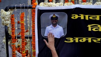 A woman touches a banner with a photo of Vinay Narwal, a Navy officer, who was killed in a terrorist attack in Pahalgam. (REUTERS)