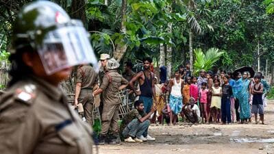 Security personnel stand guard as authorities demolish illegal residential settlements during an eviction drive inside the Paikan Reserve Forest in Goalpara district of Assam on July 12. (AFP)