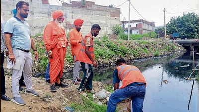 PPCB officials getting samples collected from the Jamalpur drain in Ludhiana on Saturday. (HT Photo)