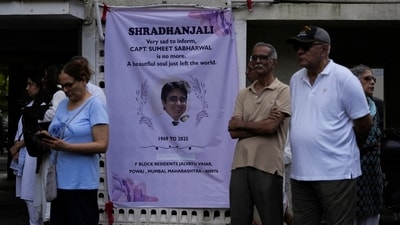 People stand next to a condolence banner as they wait for the body of Sumeet Sabharwal, captain of the Air India Boeing 787-8 Dreamliner that crashed on June 12. (REUTERS)
