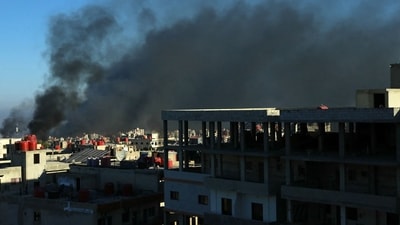 Black smoke rises above buildings in southern Syria's city of Sweida, as clashes continue between Beduin tribal forces and Druze fighters on July 19 (AFP)