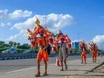 A Kanwariya devotee carries holy water along with an idol of Lord Shiva on his shoulders from the Ganga river in Haridwar, on his way back to Sohna. 