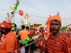 Kanwariyas carry holy water from river Ganga in plastic bottle as they walk towards temple after holy dips in Prayagraj.