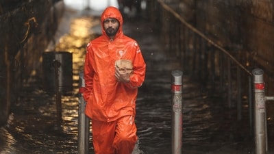A gig worker wades through a waterlogged subway amid heavy rain in Mumbai, India, July 21, 2025. (REUTERS)