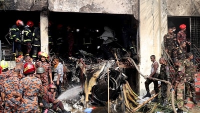 Firefighters and army members engaged in rescue work next to the wreckage of the air force training aircraft that crashed into Milestone College campus in Dhaka. (Reuters)