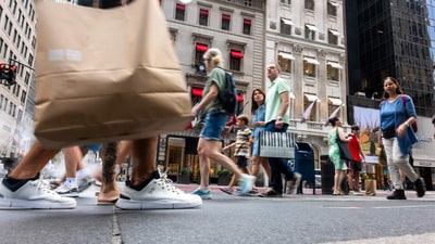 Pedestrians make their way along a stretch of Fifth Avenue storefronts in Manhattan. Pedestrians make their way along a stretch of Fifth Avenue storefronts in Manhattan.