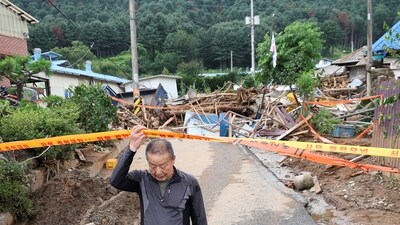 A resident leaves his house in the aftermath of torrential rain, in Gapyeong, South Korea July 21 (REUTERS)