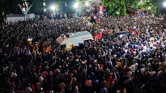 People gather outside the AKG Centre to pay their respects as the mortal remains of former Kerala chief minister and veteran CPI(M) leader V S Achuthanandan being brought in an ambulance, in Thiruvananthapuram, on Monday. (PTI)