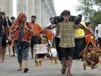 A resident of Delhi, carries the Kanwar from Haridwar along with his two nephews  during the Kanwar Yatra in Ghaziabad, India, on Monday.
