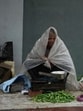 A vegetable vendor speaks on his mobile phone while the monsoon rain in Jammu on Monday. (AP) A vegetable vendor speaks on his mobile phone while the monsoon rain in Jammu on Monday. (AP)