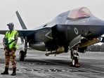 A CISF personnel stands guard near the British F-35 fighter jet that made an emergency landing after running low on fuel at the Thiruvananthapuram International Airport on June 14, 2025. A CISF personnel stands guard near the British F-35 fighter jet that made an emergency landing after running low on fuel at the Thiruvananthapuram International Airport on June 14, 2025.