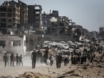 Palestinians gather to collect humanitarian aid from a distribution point in Beit Lahia, northern Gaza, on Sunday, July 20, 2025.