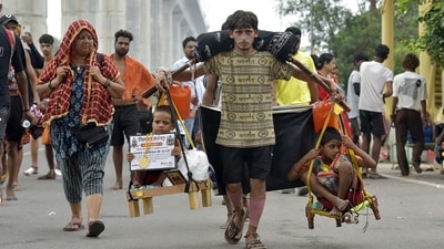 A resident of Delhi, carries the Kanwar from Haridwar along with his two nephews  during the Kanwar Yatra in Ghaziabad, India, on Monday. ( HT Photo)