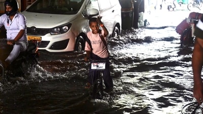 A small boy waves his hand to the cameraperson as he walks through an underpass which stands waterlogged and jammed with vehicles after the Kanwar Yatra traffic disruptions. (Raj K Raj/HT) A small boy waves his hand to the cameraperson as he walks through an underpass which stands waterlogged and jammed with vehicles after the Kanwar Yatra traffic disruptions. (Raj K Raj/HT)