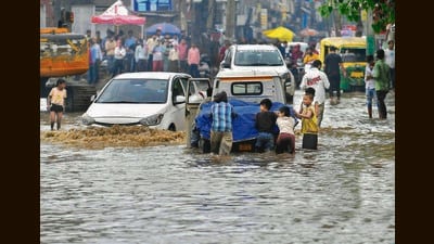 Group of people push a stranded vehicle after heavy rainfall caused waterlogging in several parts of the city on Wednesday morning. (Manish/HT) Group of people push a stranded vehicle after heavy rainfall caused waterlogging in several parts of the city on Wednesday morning. (Manish/HT)